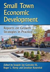 A textbook cover with a color photo of a small downtown area. The book title is Small Town Economic Development: Reports on Growth Strategies in Practice.